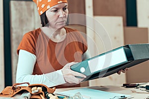 Self employed female carpenter with document ring binder