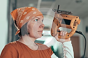 Self employed female carpenter with electric jigsaw