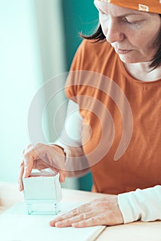 Self employed female carpenter is stamping project documentation