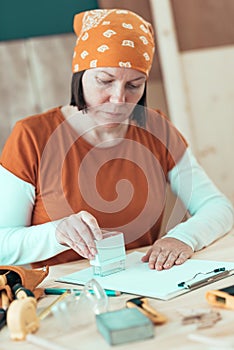 Self employed female carpenter is stamping project documentation