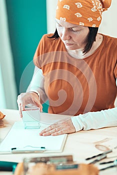 Self employed female carpenter is stamping project documentation