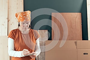 Self employed female carpenter writing project notes