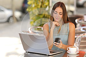 Self employed woman working with her phone and laptop in a restaurant