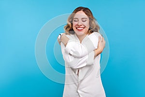 Self-esteem, love. Portrait of egoistic beautiful woman embracing herself. isolated on blue background