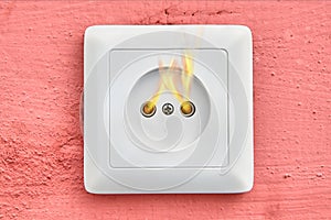Self-ignition of household wall outlet, close-up.
