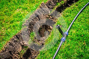 Self-installation of irrigation with a retractable sprinkler in the finished lawn. Laying water pipes with sprayers under the lawn