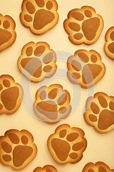 Self made cat paw cookies on beige background. Vertical photo