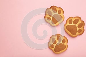 Self made cat paw cookies on pink background