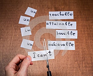 Self motivation concept. Negative words cut with scissors.