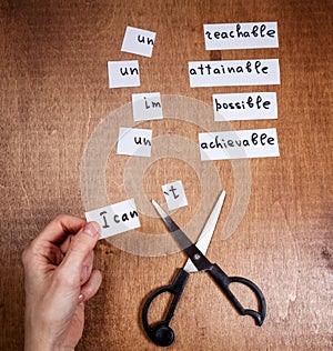 Self motivation concept. Negative words cut with scissors.