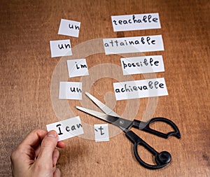 Self motivation concept. Negative words cut with scissors.