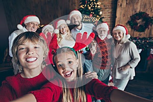 Self photo of large family meeting together with couple of brother sister taking selfie on background of their relatives