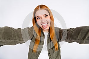 Self-portrait of attractive foolish cheerful girl having fun grimacing isolated over gray pastel color background