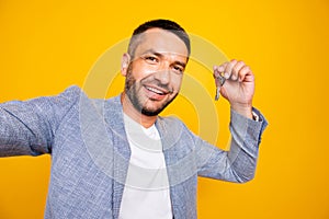 Self-portrait of his he nice-looking attractive cheerful cheery positive glad guy wearing grey blazer holding in hands