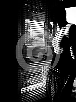 Self portrait of male model shirtless and looking out a window