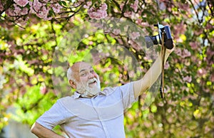 Self portrait. Memories in snap. Everyone photogenic. Senior man taking selfie photo vintage camera. Retro equipment for