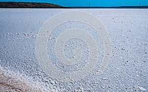 Self-precipitating table salt sodium chloride on the surface of a dried-up reservoir .