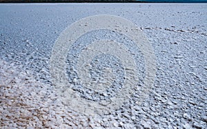 Self-precipitating table salt sodium chloride on the surface of a dried-up reservoir .