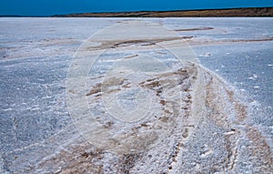 Self-precipitating table salt sodium chloride on the surface of a dried-up reservoir.