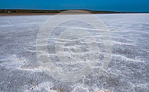 Self-precipitating table salt sodium chloride on the surface of a dried-up reservoir .