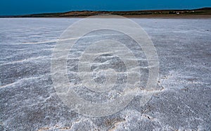 Self-precipitating table salt sodium chloride on the surface of a dried-up reservoir .