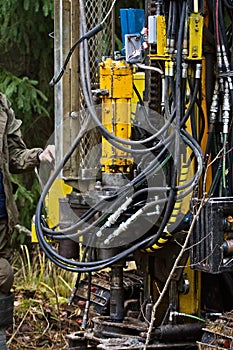 Self-propelled drilling rig drills the soil in forest conditions photo