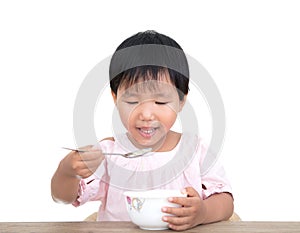 The self-reliant child in front of a white background is eating by himself