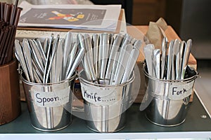 Self-service catering establishment. Stacked knives, forks, and spoons in the kitchen of the restaurant.