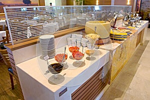 Self service restaurant and barbecue steakhouse. Cheese, peper and hot food table.