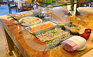 Self service restaurant and barbecue steakhouse with sushi table.