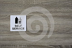 Self service sign on the wooden wall with space for adding text on the right side