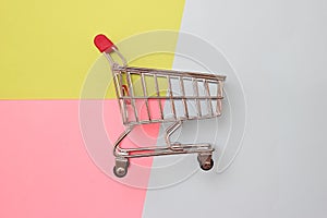Self-service supermarket full shopping trolley cart on colorful background