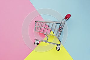 Self-service supermarket full shopping trolley cart on colorful background