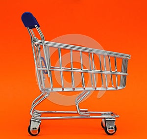 Self-service supermarket full shopping trolley cart on colorful background