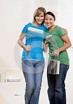 Self-sufficient friends painting with paint roller photo