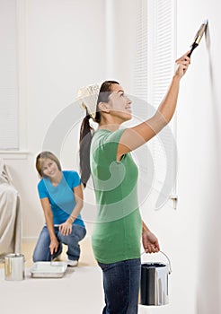 Self-sufficient woman painting with paint brush