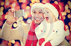 Selfe in Christmas. happy family dad with daughter and photographed on mobile phone