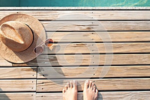 Selfie of barefoot on wooden floor with sun hat and sunglasses. Summer concept