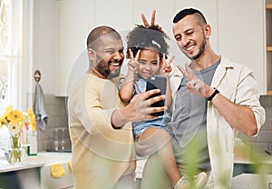 Selfie, blended family and a happy girl with her gay parents in the kitchen together for a profile picture. Adoption