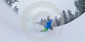 SELFIE: Breathtaking shot of male snowboarder speeding down the ungroomed slope. photo