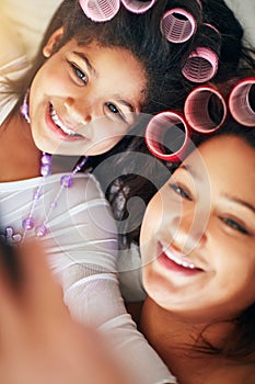 Selfie, child and mother with hair rollers in bedroom for photo, pamper or bonding together on mothers day. Top view photo
