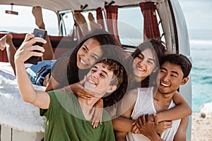 Selfie concept, hugging boyfriend from back at retro van