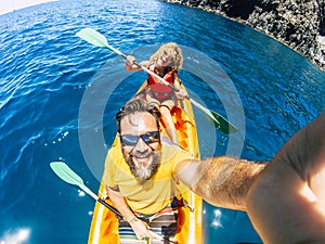 Selfie couple with top vertical point of view - happy active adult people enjoy kayak at the ocean - summer tourist in holiday