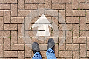 Selfie of feet and arrows on the road. top view. Businessmen in black shoes standing on a road with many white arrow pathway sign