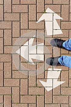 Selfie of feet and arrows on the road. top view. Businessmen in black shoes standing on a road with many white arrow pathway sign