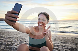 Selfie, fitness and woman on beach peace sign, live streaming her workout, training or exercise results. Video call of