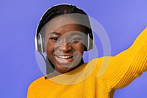 Selfie Fun. Cheerful Black Lady In Wireless Headphones Taking Self-Portrait, Closeup Shot