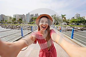 Selfie girl in Floripa. Happy laughing fashion woman takes self portrait in the city of Florianopolis, Santa Catarina, Brazil
