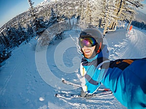 Selfie Guy sportsman goes on normal skiing on ski slope with action camera Sheregesh