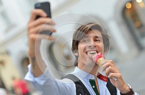 Selfie of handsome young man eating ice cream